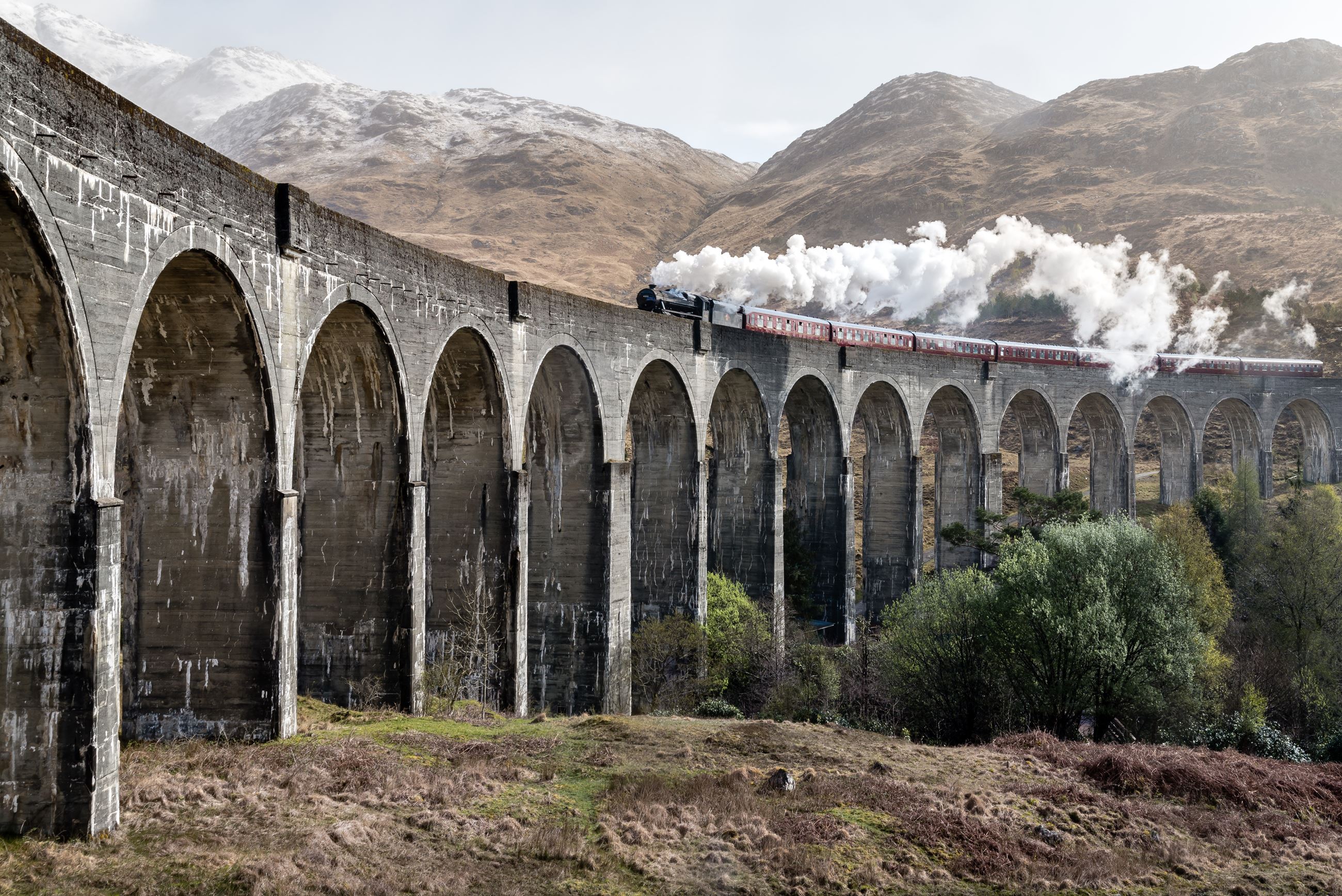 Train going over arched bridge in Europe Countryside